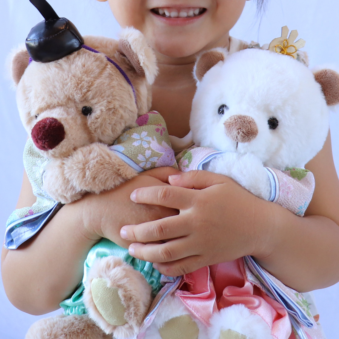 クマの雛人形と子どもが遊んでいるイメージ
